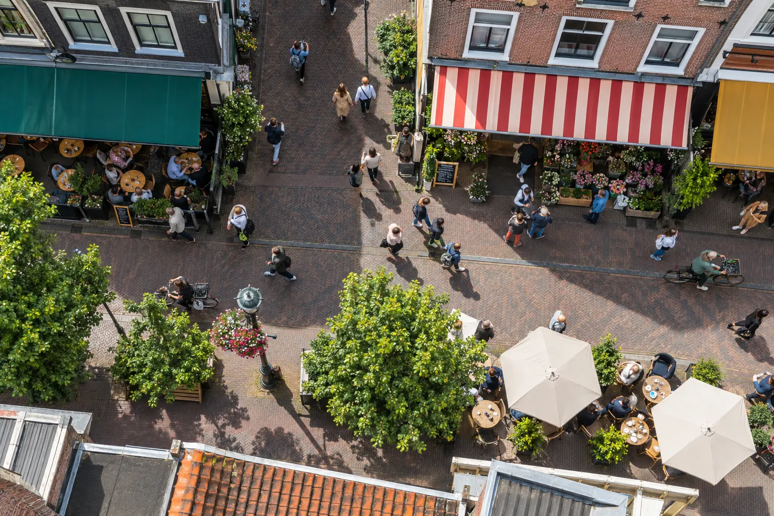 Winkelstraat van bovenaf met terrassen, winkels en voorbijgangers